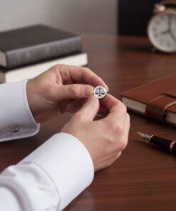 Muž pripevňuje manžetové gombíky Váhy na bielu formálnu košeľu