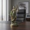Socha spravodlivosti Themis v bronzovom prevedení umiestnená na pracovnom stole v advokátskej kancelárii