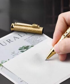 Luxusné pero s drakom v zlatom vyhotovení pri písaní na biely papier. — luxusné perá s drakom