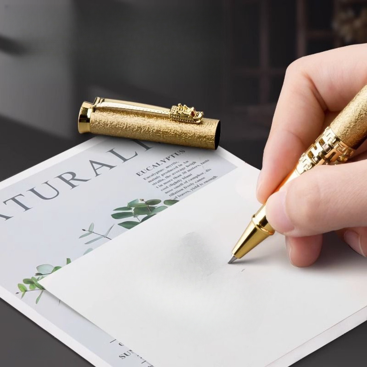 Luxusné pero s drakom v zlatom vyhotovení pri písaní na biely papier. — luxusné perá s drakom